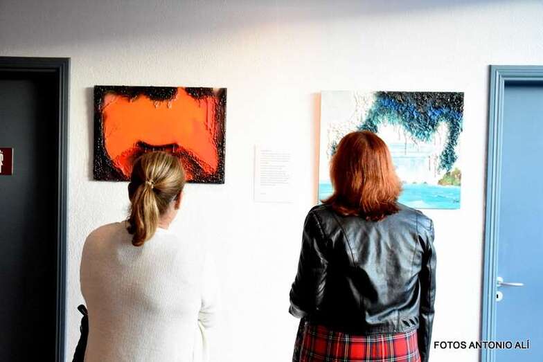 Dos personas observan cuadros de la exposición (Foto Antonio Alí)
